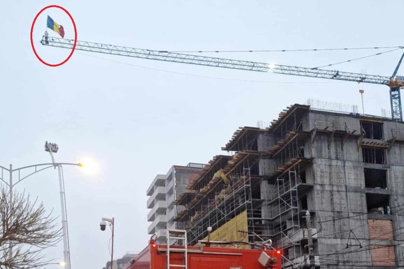 FOTO/VIDEO „Stegarul Dac” s-a suit pe o macara, în București, fluturând steagul României, și refuză să coboare. Mesaj live transmis pe Facebook