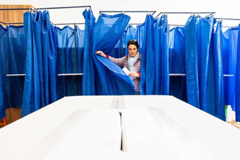 O femeie iese dintr-o cabină de vot într-o secție de votare din București, România, pe 18 mai 2025, în timpul turului doi al alegerilor prezidențiale. Foto: Mihai Barbu / AFP / Profimedia