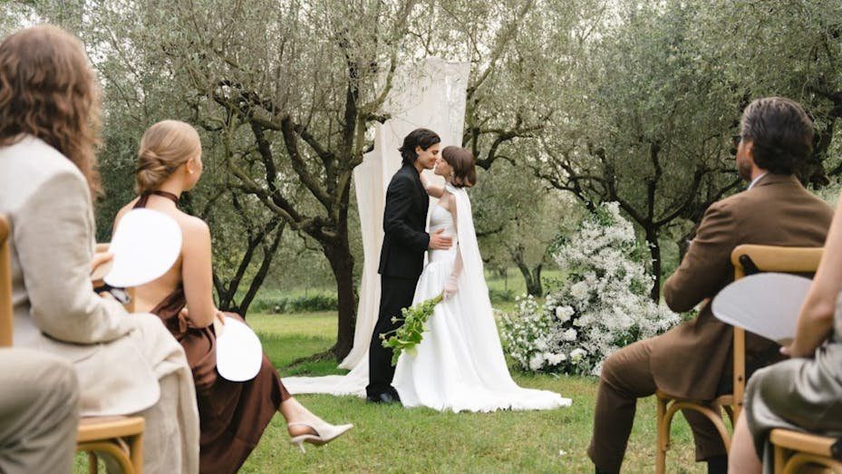 A beautiful outdoor wedding ceremony in Torroella de Montgrí, Spain with the couple and guests.